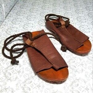 Brown Free People flat leather sandles with suede braided wrap around ankle. Lea